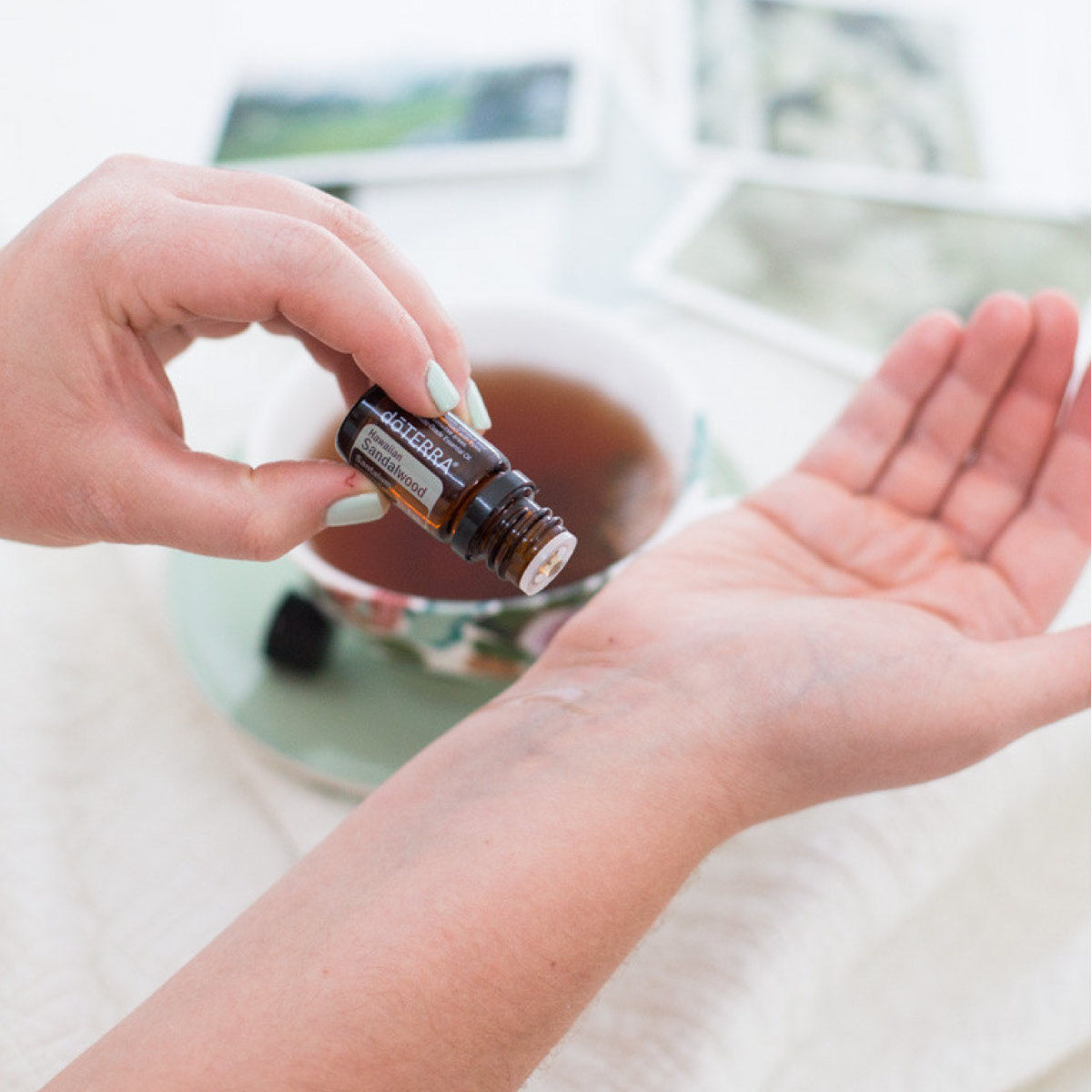 Woman pouring Hawaiian Sandalwood oil on her wrist. Wondering how to use Hawaiian Sandalwood essential oil? Hawaiian Sandalwood oil can be used for meditation, to promote smooth skin, or to create a calming environment. 